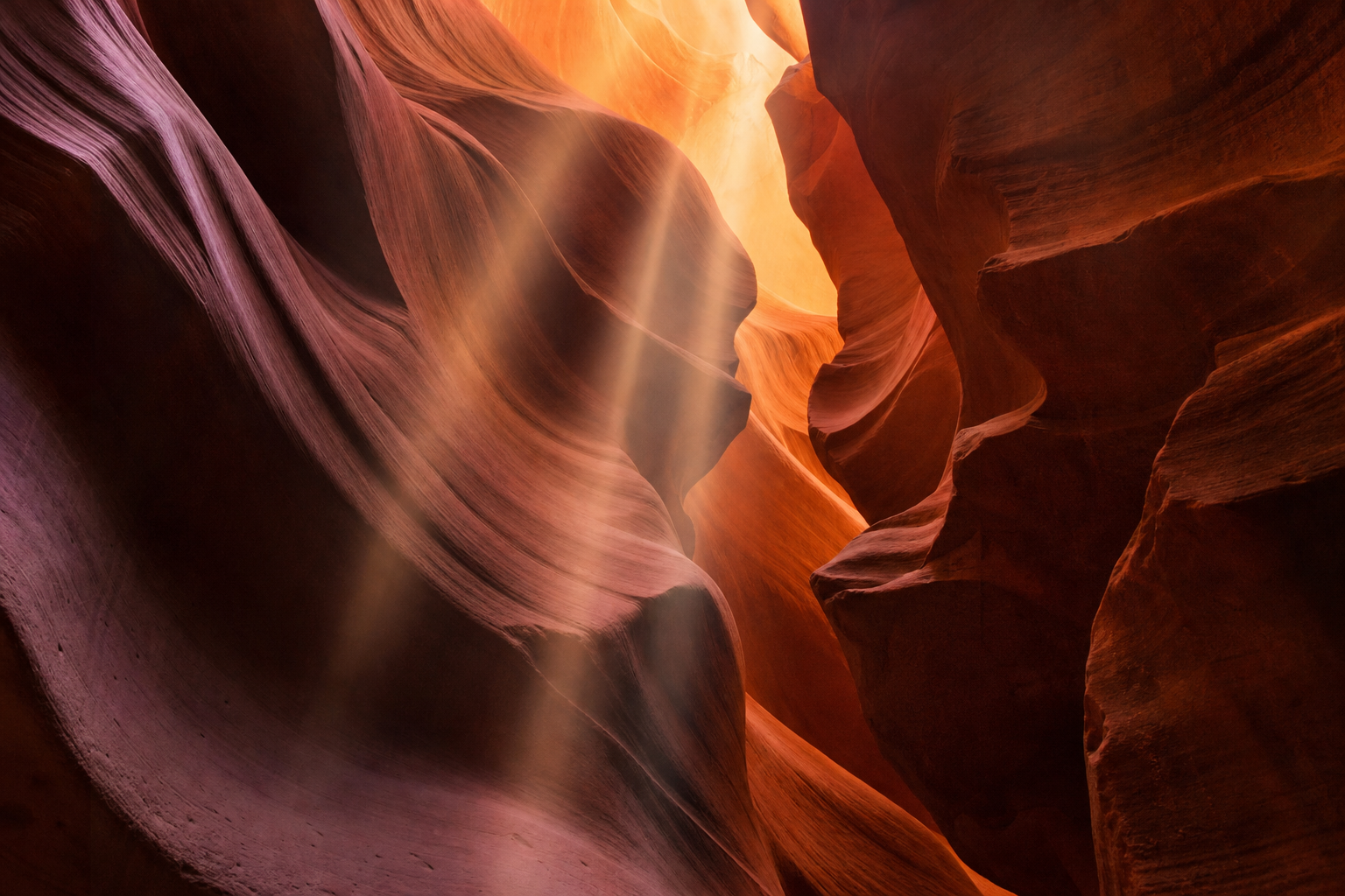 Antelope Canyon Arizona sandstone slot canyon, flowing curved walls in warm orange and magenta, light beams streaming from above, real photograph, nature photography