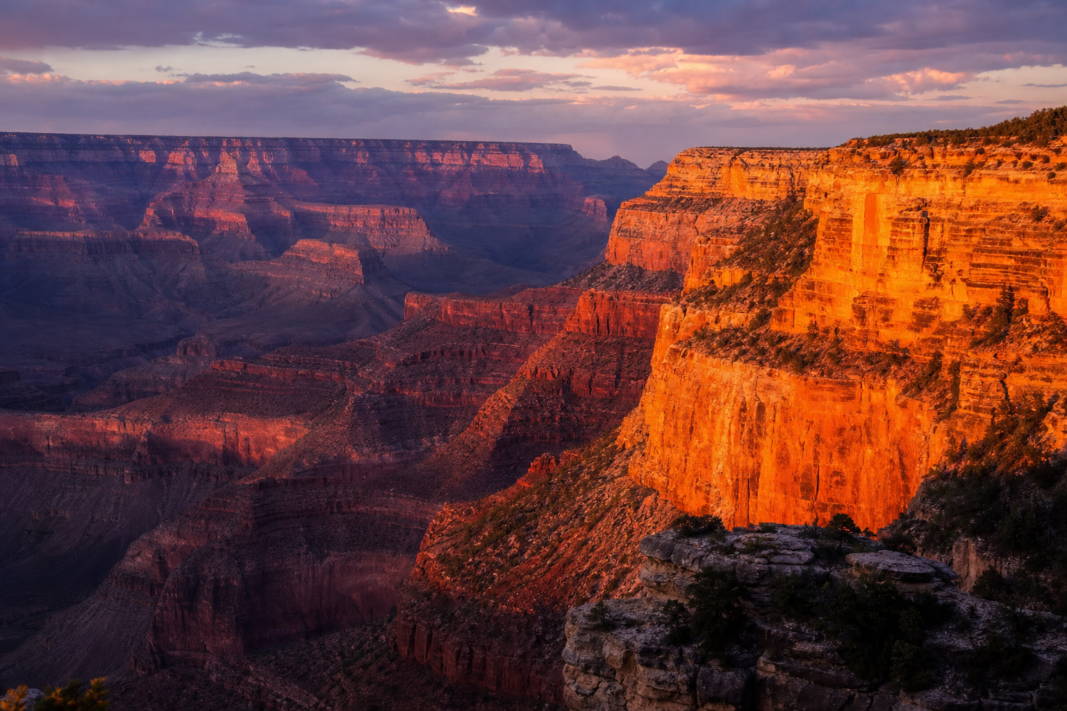 The Grand Canyon at sunset, vast layered red rock cliffs glowing in deep orange crimson and violet light, dramatic canyon shadows, real photograph, landscape photography