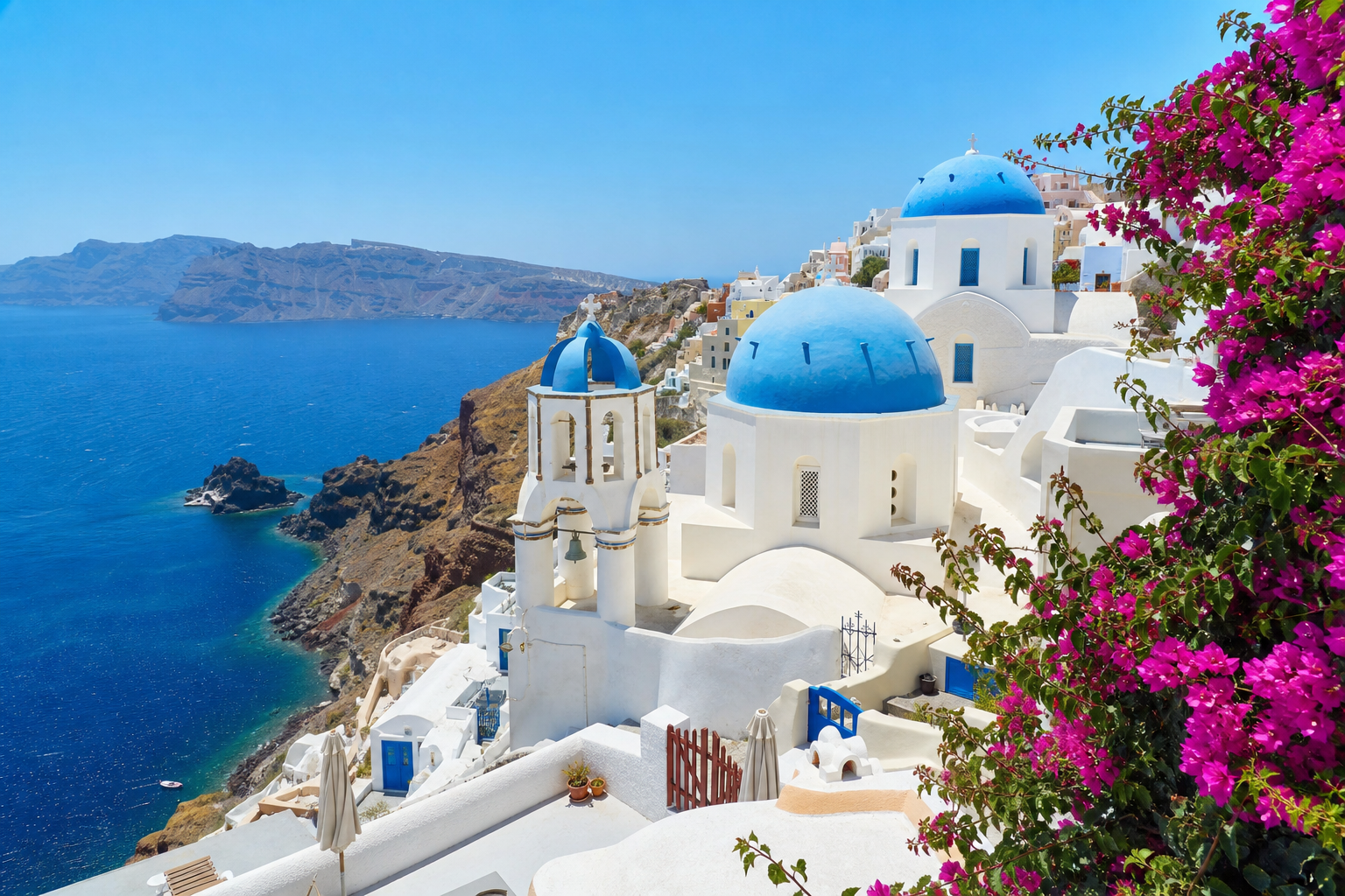 Mykonos Greece whitewashed buildings and blue-domed church overlooking the Aegean sea, bright Mediterranean sunlight, cascading bougainvillea, real photograph, travel photography